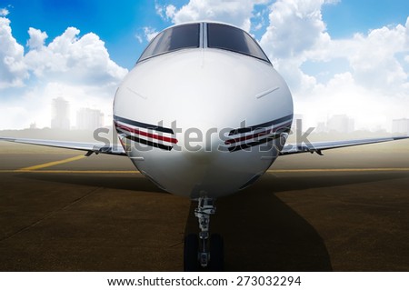 Private jet airplane parking at the airport. With city and blue sky background