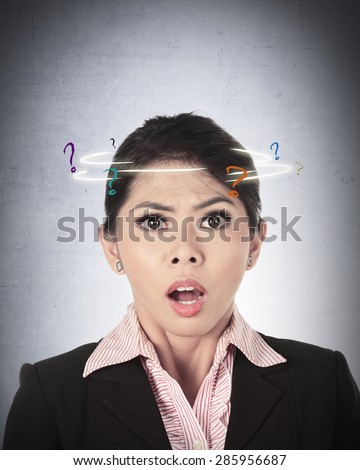 Asian business woman confused with question mark around her head