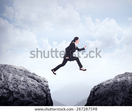 Business woman jumping across hill. Business challenge conceptual