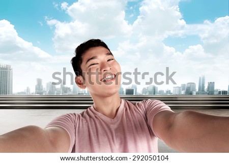 Handsome man doing selfie with cityscape background