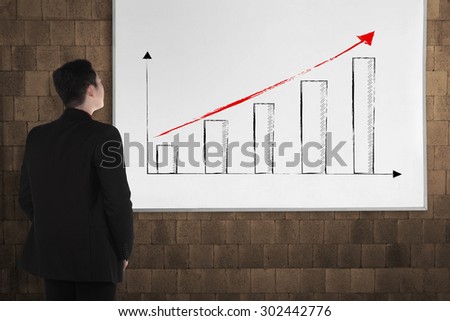 Back view young man with white board. There increasing chart image