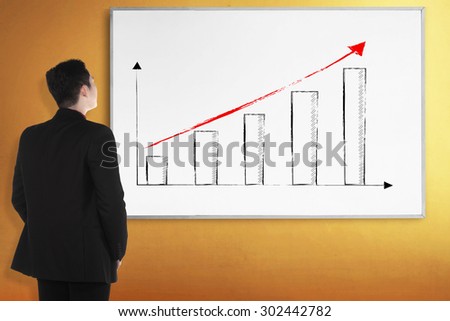 Back view young man with white board. There increasing chart image