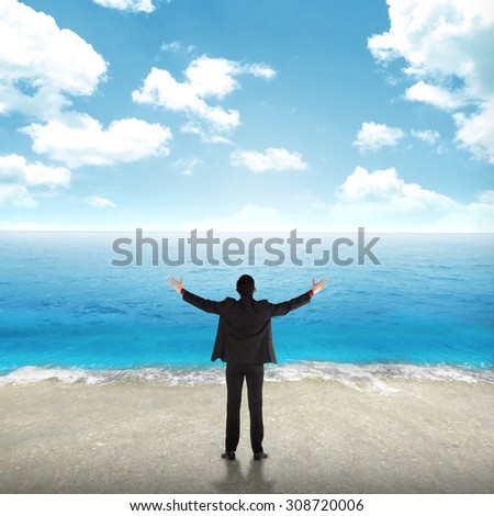 Successful business man on the beach with blue sky background