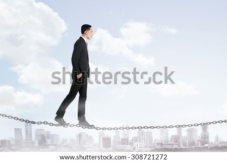 Business man walking on the chain. Business risk concept