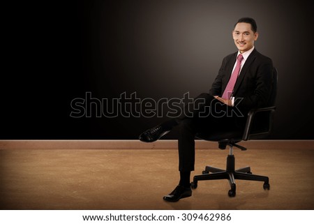 Business man sitting on the chair with black background