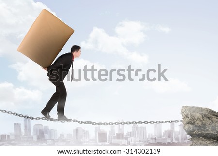 Business man carry heavy package, walking on the chain