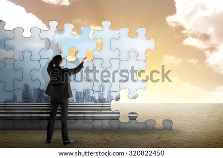 Business person building puzzle of city in the desert. Business building concept