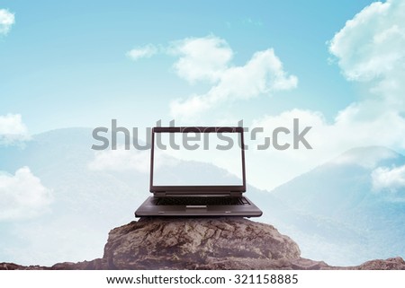 Laptop on the top of the mountain. You can put your design on computer