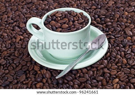 Coffee bean in the coffee cup shot with coffee bean background