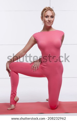 Beautiful sexy blonde with perfect athletic slim figure engaged in yoga, pilates, exercise or fitness, lead healthy lifestyle, and eats right, dressed in comfortable casual clothes relaxes meditation