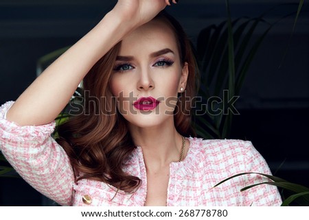 Beautiful stylish young fashion girl with perfect evening make-up with pink lips and green eyes, staying near swimming pool in elegant summer clothes hills, skirt, top and jacket, and golden bijou