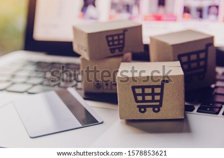 Online shopping - Paper cartons or parcel with a shopping cart logo and credit card on a laptop keyboard. Shopping service on The online web and offers home delivery. Foto stock © 