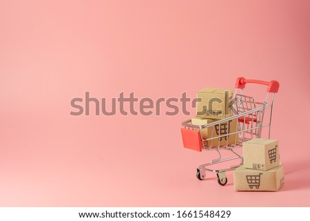 Shopping concept : Cartons or Paper boxes in red shopping cart on pink background. online shopping consumers can shop from home and delivery service. with copy space Сток-фото © 