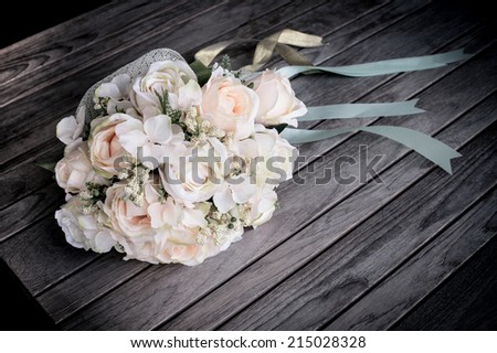 bouquet of roses on wooden table,Wedding bouquet of yellow and white roses and blue fresia lying on wooden floor
