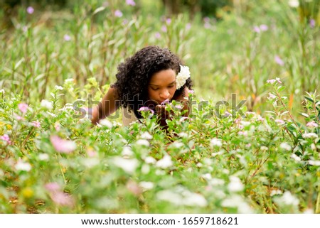 Similar – Image, Stock Photo Cheerful black woman smelling aromatic flower in hothouse