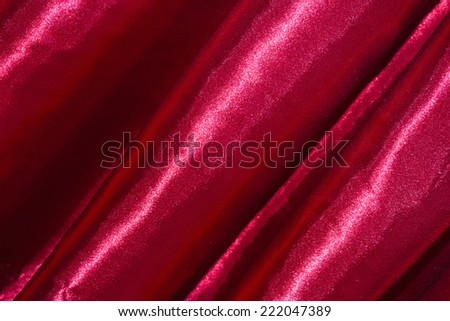Red background, closeup of red silk textured cloth background. unfocused