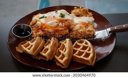 Chicken n’ Waffles. The meal contains battered chicken breast, waffle, black pepper cream gravy, cholula sauce, and bourbon maple glaze Foto stock © 