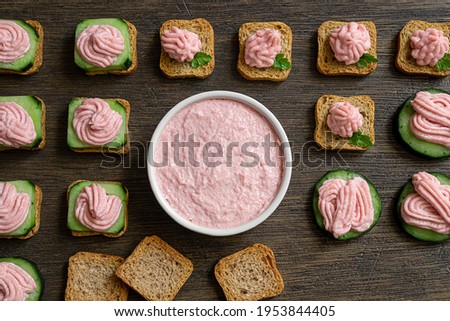 Variety of toasts with tarama and white bowl with taramasalata on a dark wooden table, top view Stok fotoğraf © 
