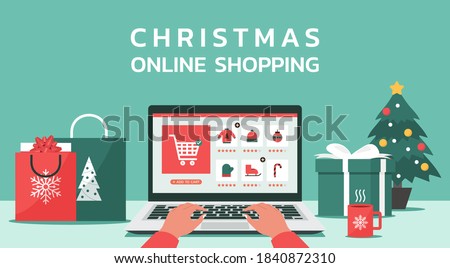 Christmas online shopping concept, human hand makes order on laptop screen with gift boxes, shopping bags on the desk, and text, winter holidays sales, flat vector illustration