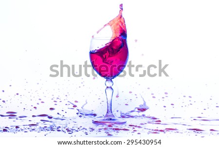 purple and red water in wine glasses splash on white background