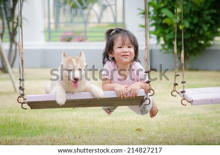 Asian baby  baby on swing with siberian husky puppy