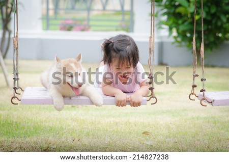 Asian baby  baby on swing with siberian husky puppy