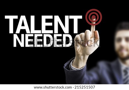 Business man pointing to black board with text: Talent Needed