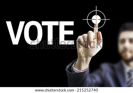 Business man pointing to black board with text: Vote