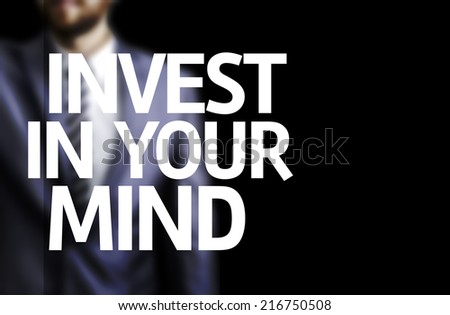 Invest In Your Mind written on a board with a business man on background