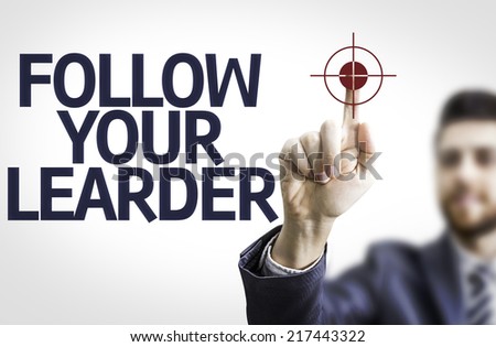 Business man pointing to transparent board with text: Follow your Leader