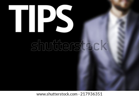 Tips written on a board with a business man on background