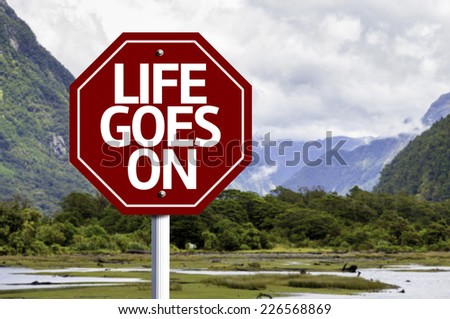Life Goes On wooden sign with a landscape background