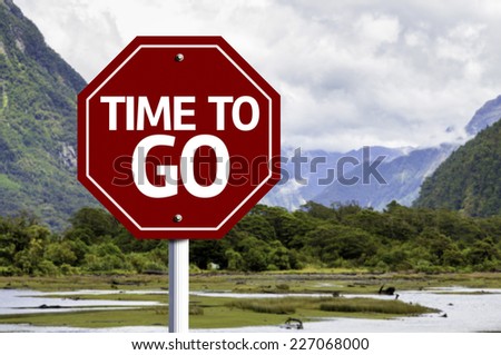 Time to Go written on red road sign with landscape background
