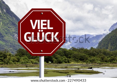 Good Luck (In German) written on red road sign with landscape background