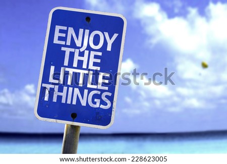 Enjoy the Little Things sign with a beach on background