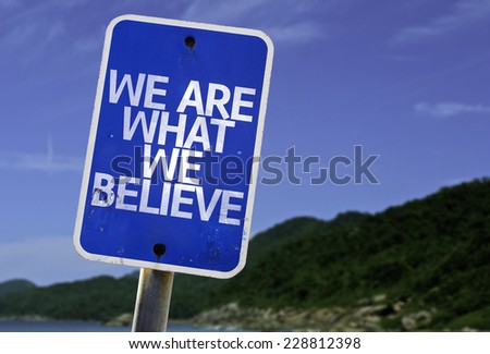 We Are What We Believe sign with a beach on background