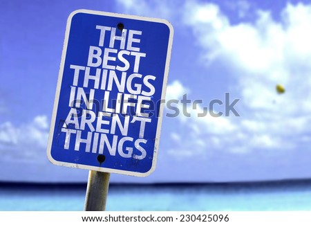 The Best Things In The Life Aren\'t Things sign with a beach on background