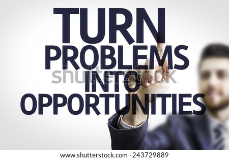 Business man pointing to transparent board with text: Turn Problems into Opportunities