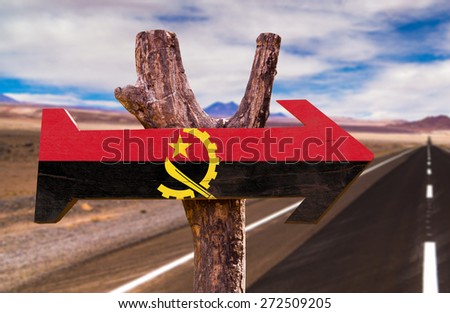 Angola Flag wooden sign with desertic road background