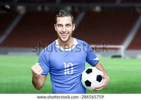 Soccer fan celebrates with blue t-shirt on stadium background