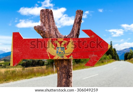 Montenegro Flag wooden sign with road background