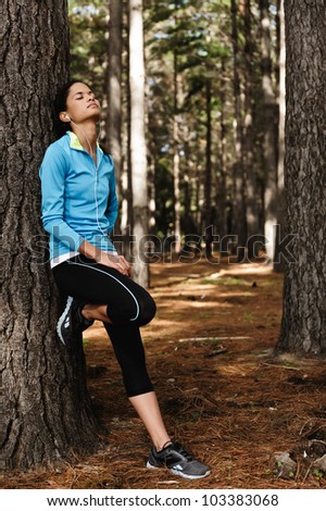 Healthy fitness woman resting in woods after a trail run. vitality relaxing athlete