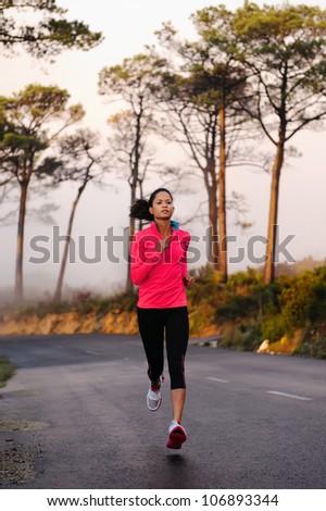 Running on the road in the misty morning. woman athlete training