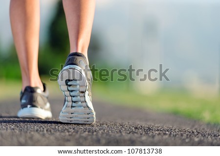 feet of an athlete running on a park pathway training for fitness and healthy lifestyle