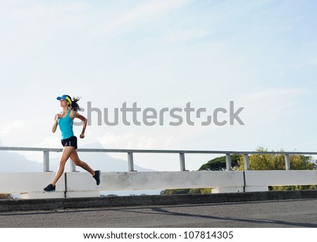 Athlete running on bridge. action shot of runner in mid air. healthy lifestyle fitness woman