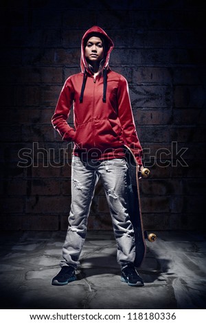 skateboarder portrait extreme sport skater with grunge wall and red hoodie