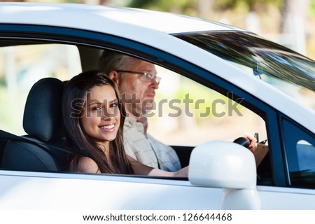 Learner driver student driving car with instructor. happy and confident smiling girl