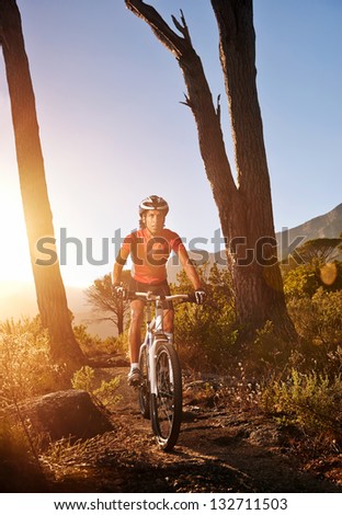 Mountain Bike cyclist riding single track at sunrise healthy lifestyle active athlete doing sport