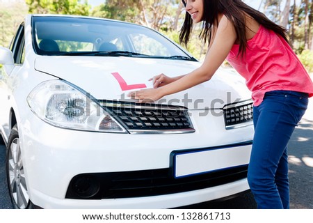 Confident learner driver girl proud of passing her test with car