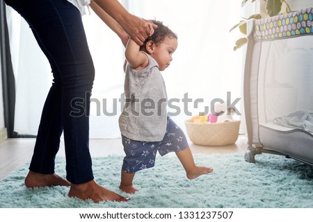 Similar – Image, Stock Photo Toddler learning to walk using push toy; child reaching to play with toy on front of walker